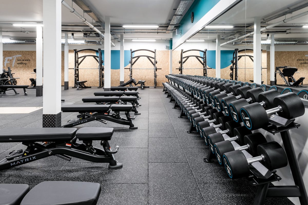PureGym Cannock Orbital Retail Park: Rows of exercise bikes, treadmills, and weight benches in a fitness studio.