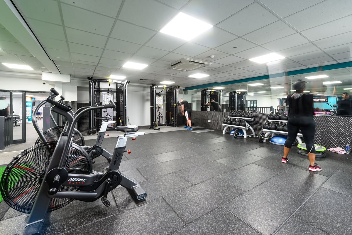 PureGym Burnham: Weight machines, free weights, rubberized flooring in a gym setting with mirrored walls.