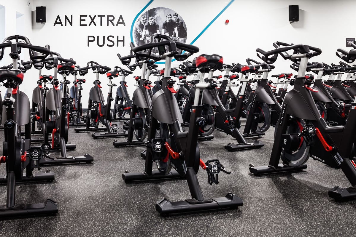 PureGym Manchester Stretford: Rows of stationary exercise bikes with motivational signage on the wall.