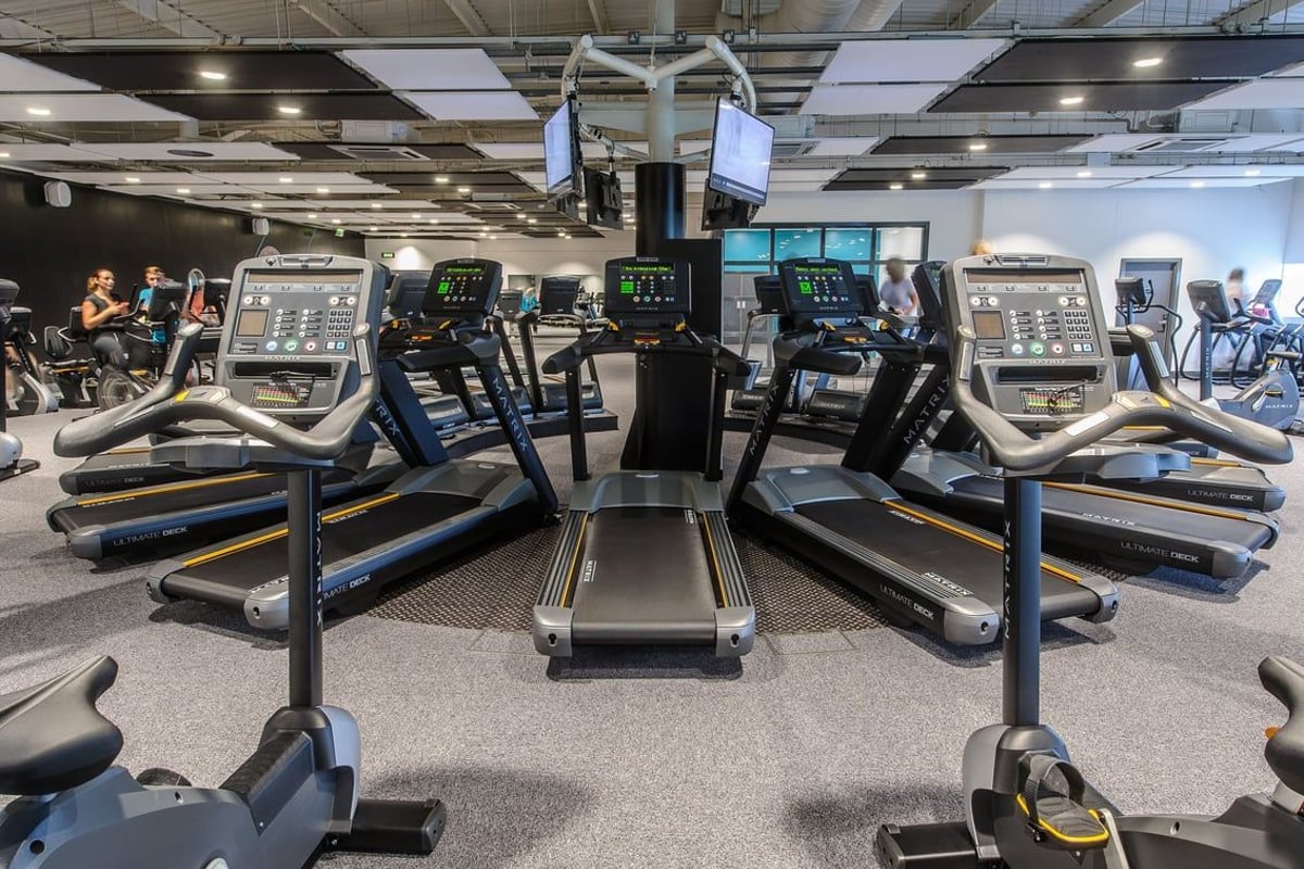 PureGym Denton: Rows of treadmills, ellipticals, and exercise bikes in a well-lit gym space.