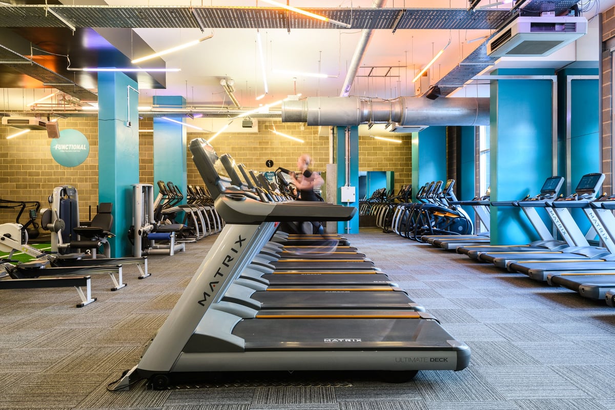 PureGym London Borough: Rows of treadmills, exercise bikes, and weight training equipment in a brightly lit gym interior.