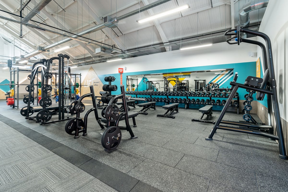 PureGym Kendal: Weight racks, benches, dumbbells, resistance machines in an industrial-style gym interior.