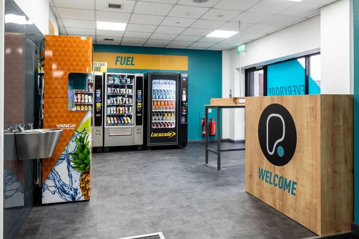PureGym Belfast Boucher Road: Vending machines offering fuel items, welcome sign, functional area.