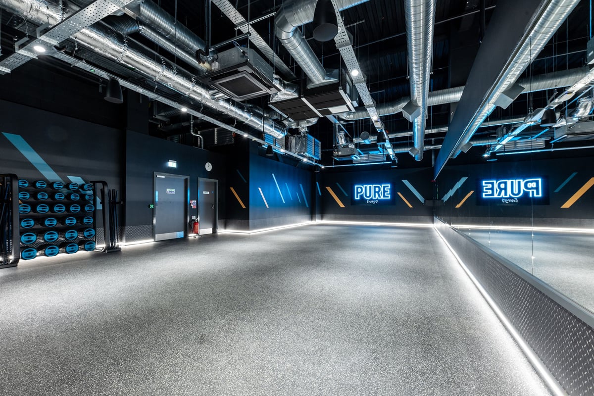 PureGym Hatfield: Gaming studio with branded walls, equipment lockers, and rubberized floor.