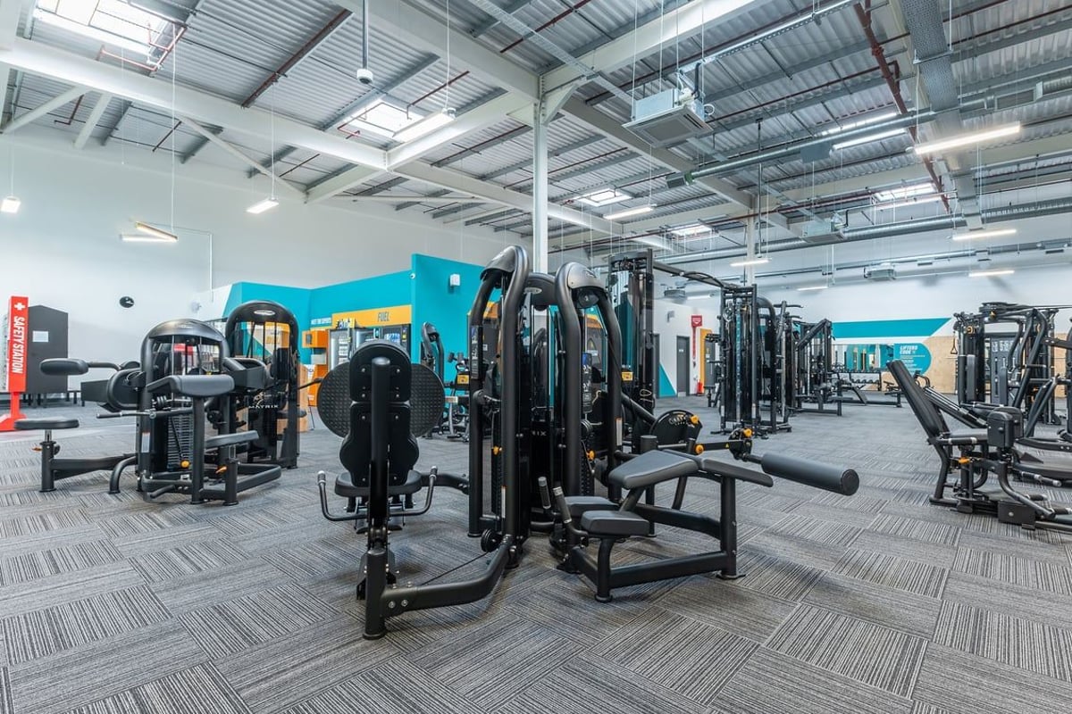 PureGym Nottingham Colwick: Fitness area with resistance machines, weight racks, free weights, and rubberized flooring.