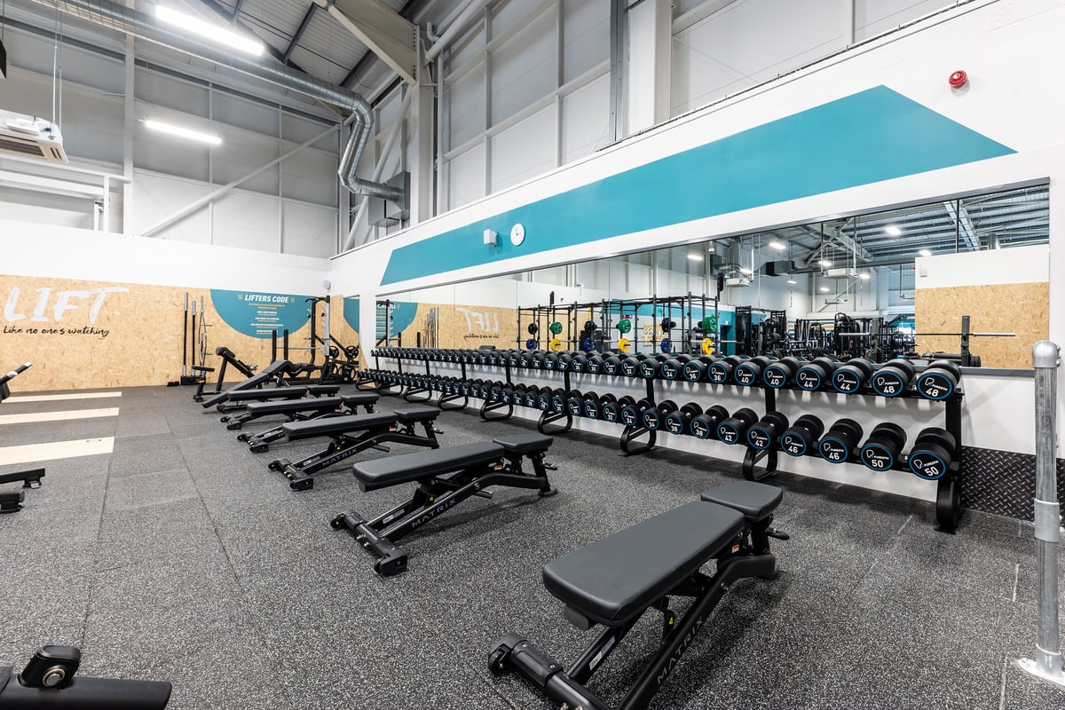 PureGym Durham City Retail Park: Rows of weight benches, dumbbells, and weight racks on rubberized flooring.