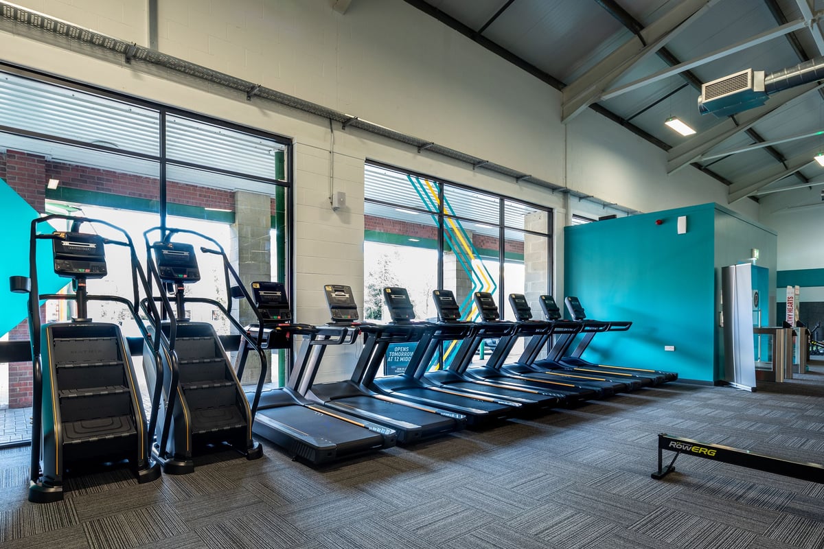 PureGym Ebbw Vale: Rows of treadmills, ellipticals, and exercise bikes in a bright gym space.