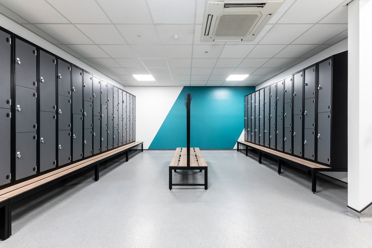 PureGym Reading Basingstoke Road: Lockers, benches, and a teal accent wall in a changing room setting.