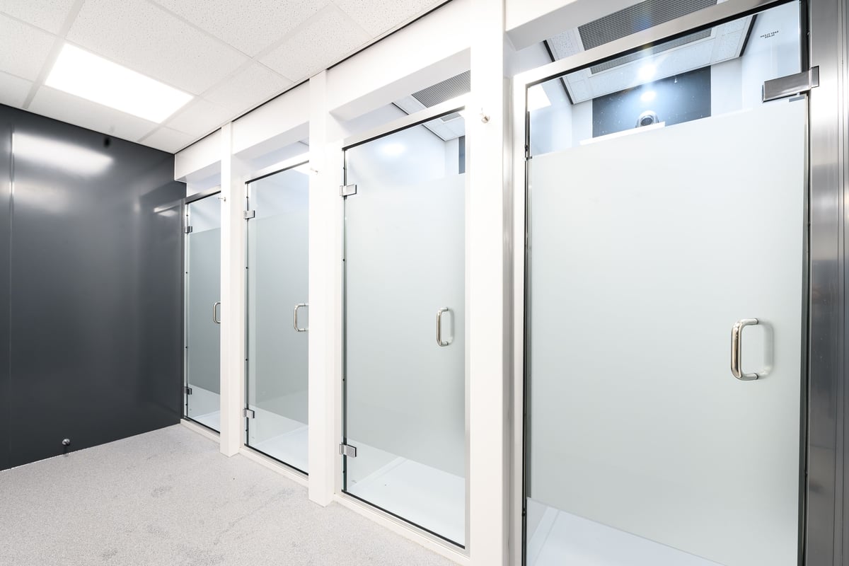 PureGym London East Sheen: Shower stalls with frosted glass doors.