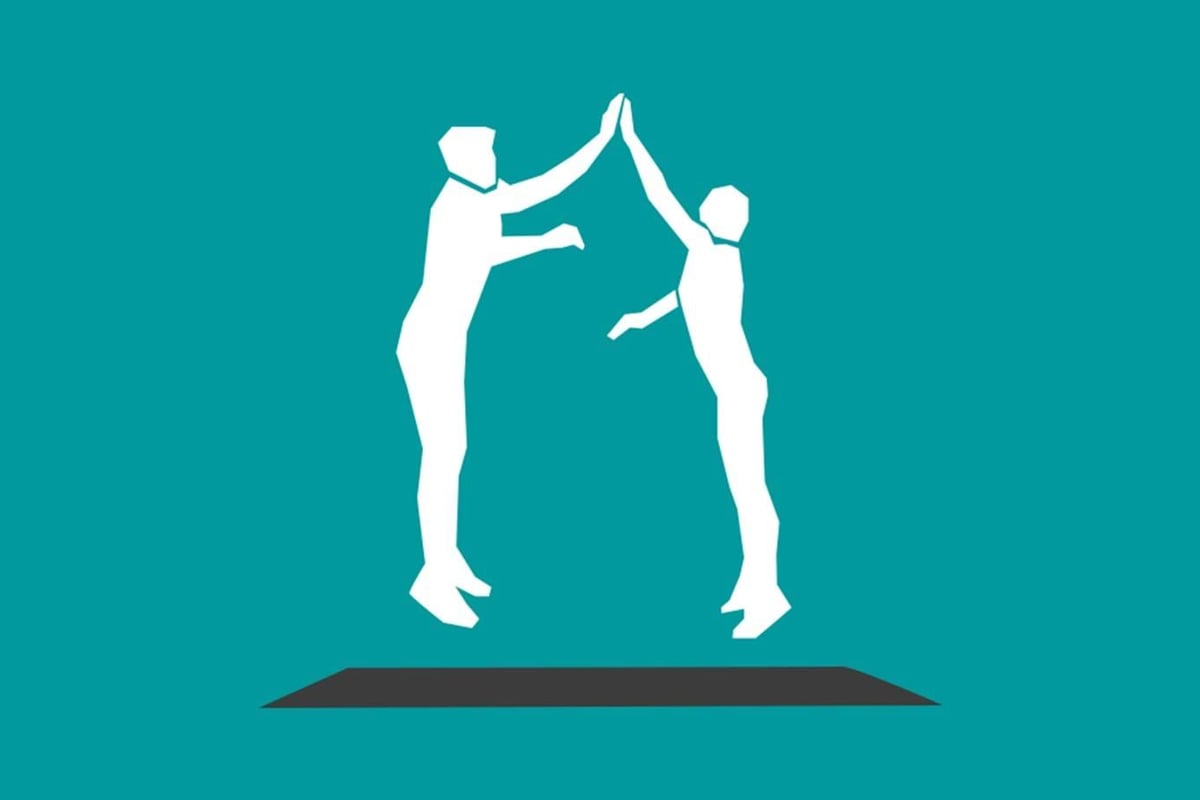 Two white silhouettes jumping and giving a high five on a teal background