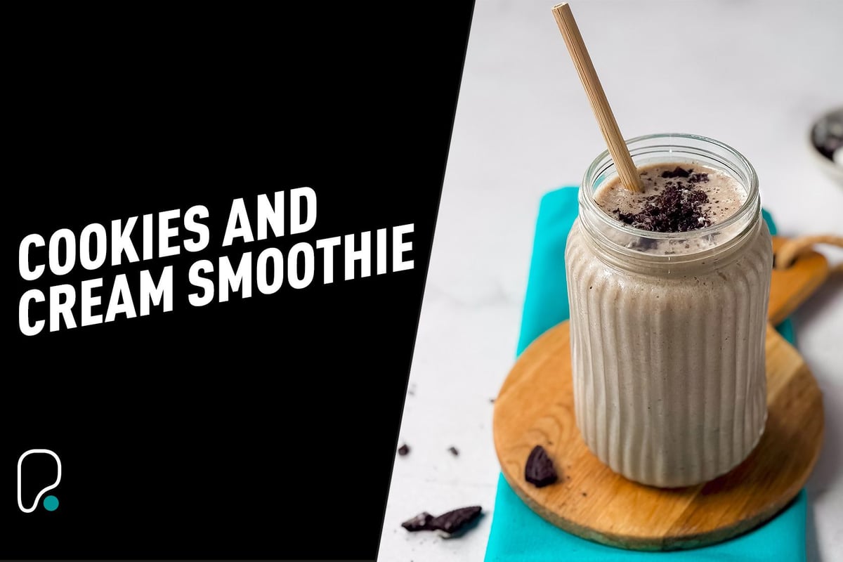 Cookies and cream smoothie in a glass jar with a wooden straw on a wooden board