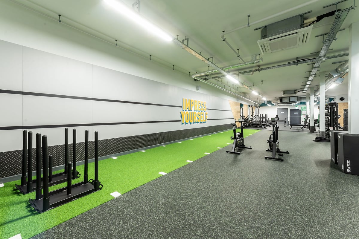 PureGym Macclesfield Silk Road: Gym studio with weight racks, turf area, free weights, and black rubber flooring.