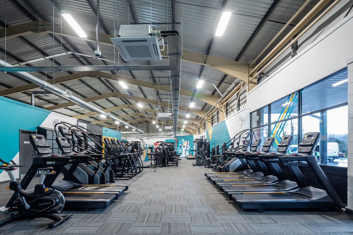 PureGym Neath: Rows of treadmills, ellipticals, and exercise bikes in a brightly lit gym.