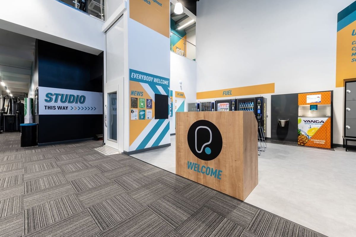 PureGym Edinburgh Craigleith Retail Park: Gym entry lobby with branding, information screens and welcome sign.