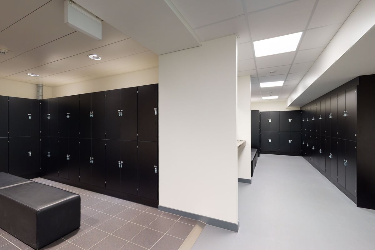 PureGym Bern Lorraine: Des rangées de casiers noirs et un banc dans quel vestiaire.