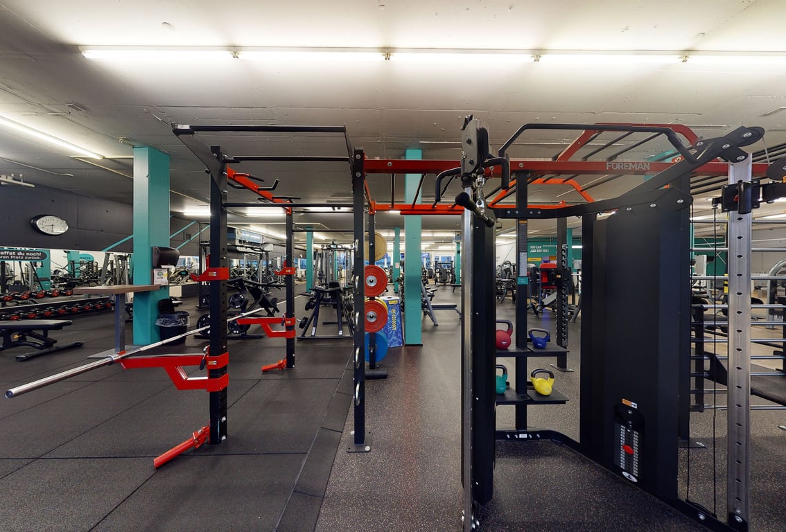 PureGym Wettingen: Reihen von Widerstandsmaschinen und Gestellen mit Gewichten.