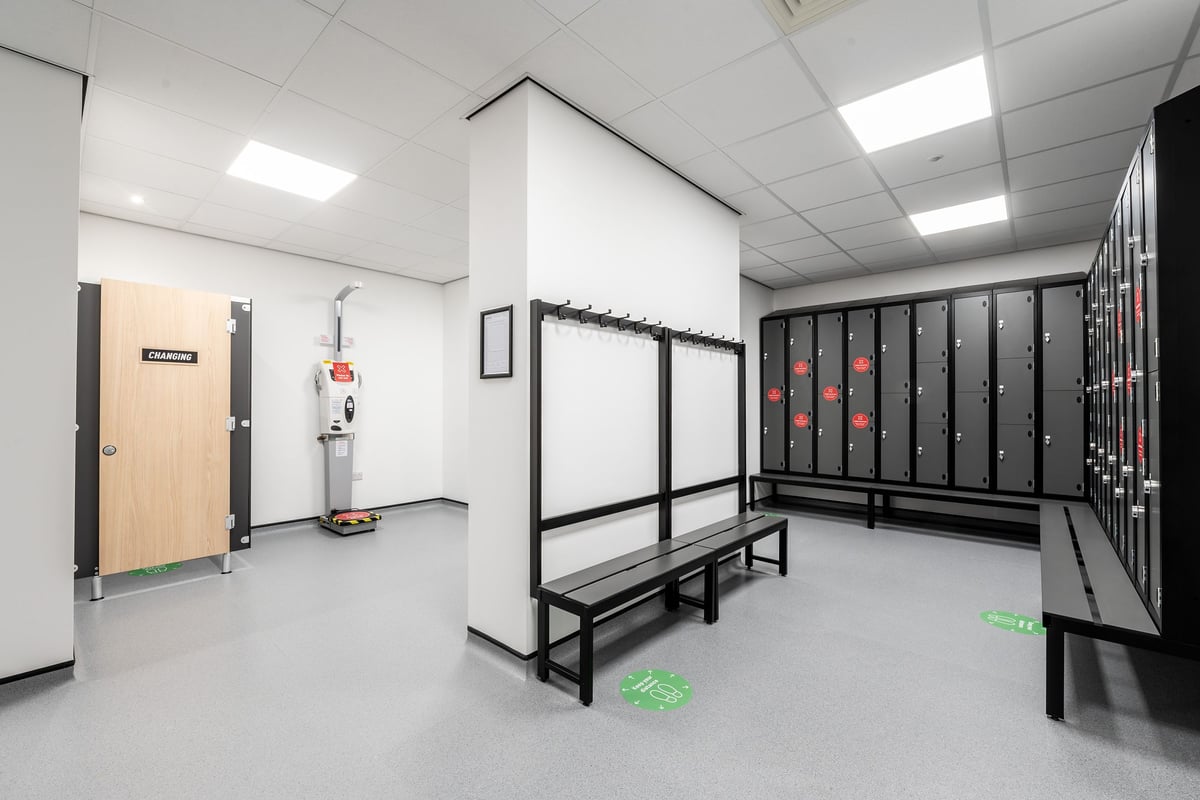 PureGym Birmingham Longbridge: Lockers, benches, and an equipment storage room without fitness machines.