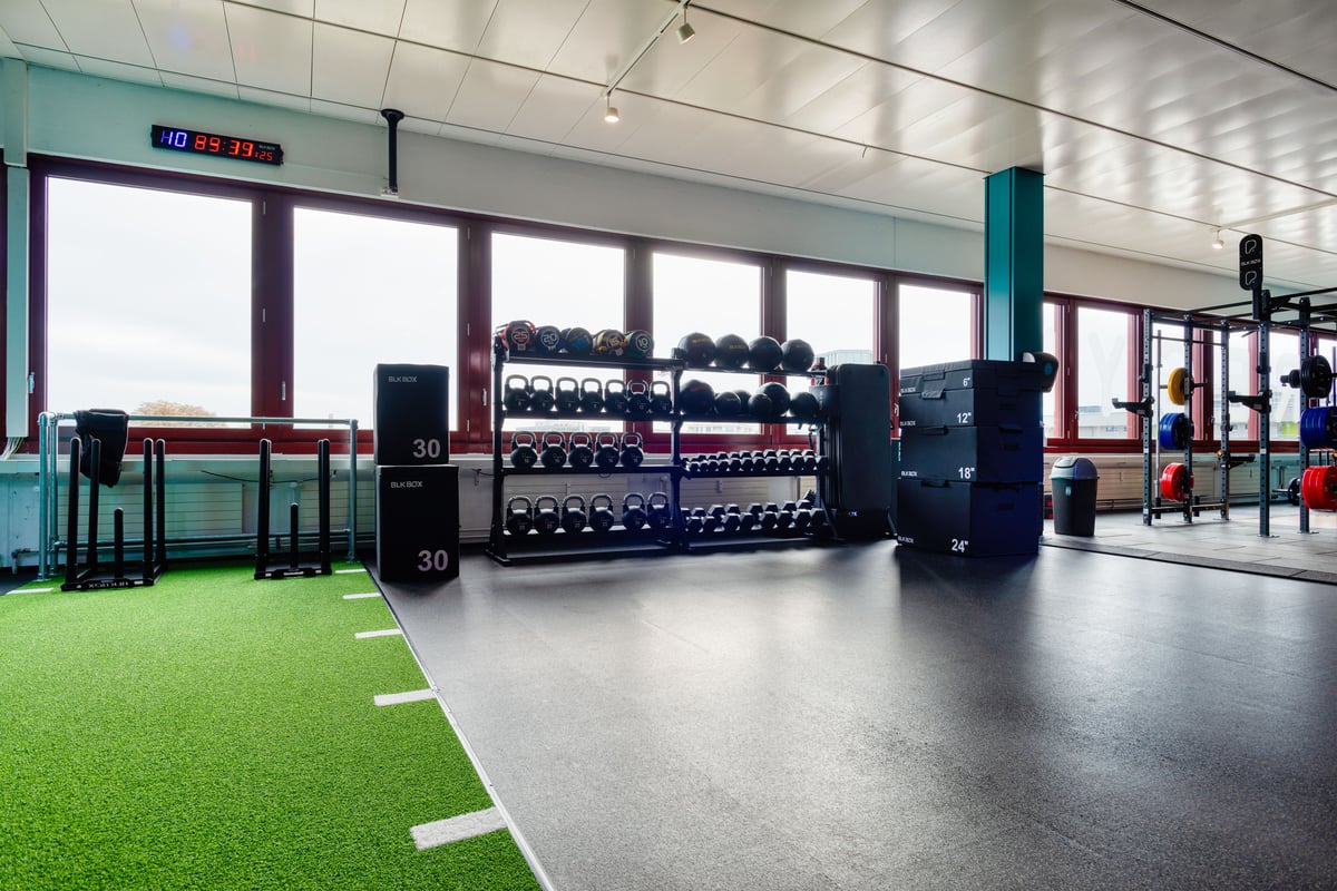 Zone fonctionnelle du gym avec kettlebells et tapis synthétique