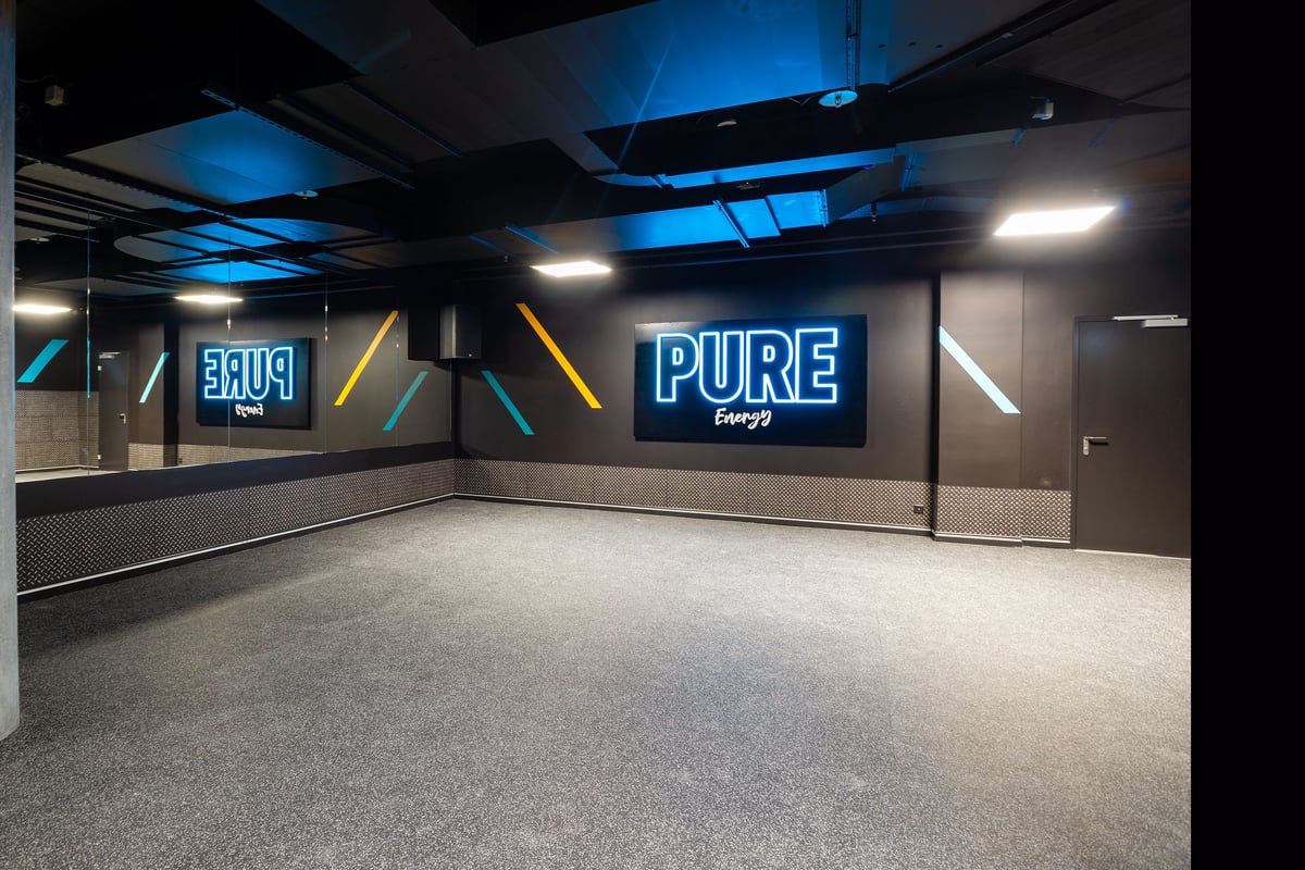 PureGym Genf Le Bouchet: Open studio space with mirrored wall.