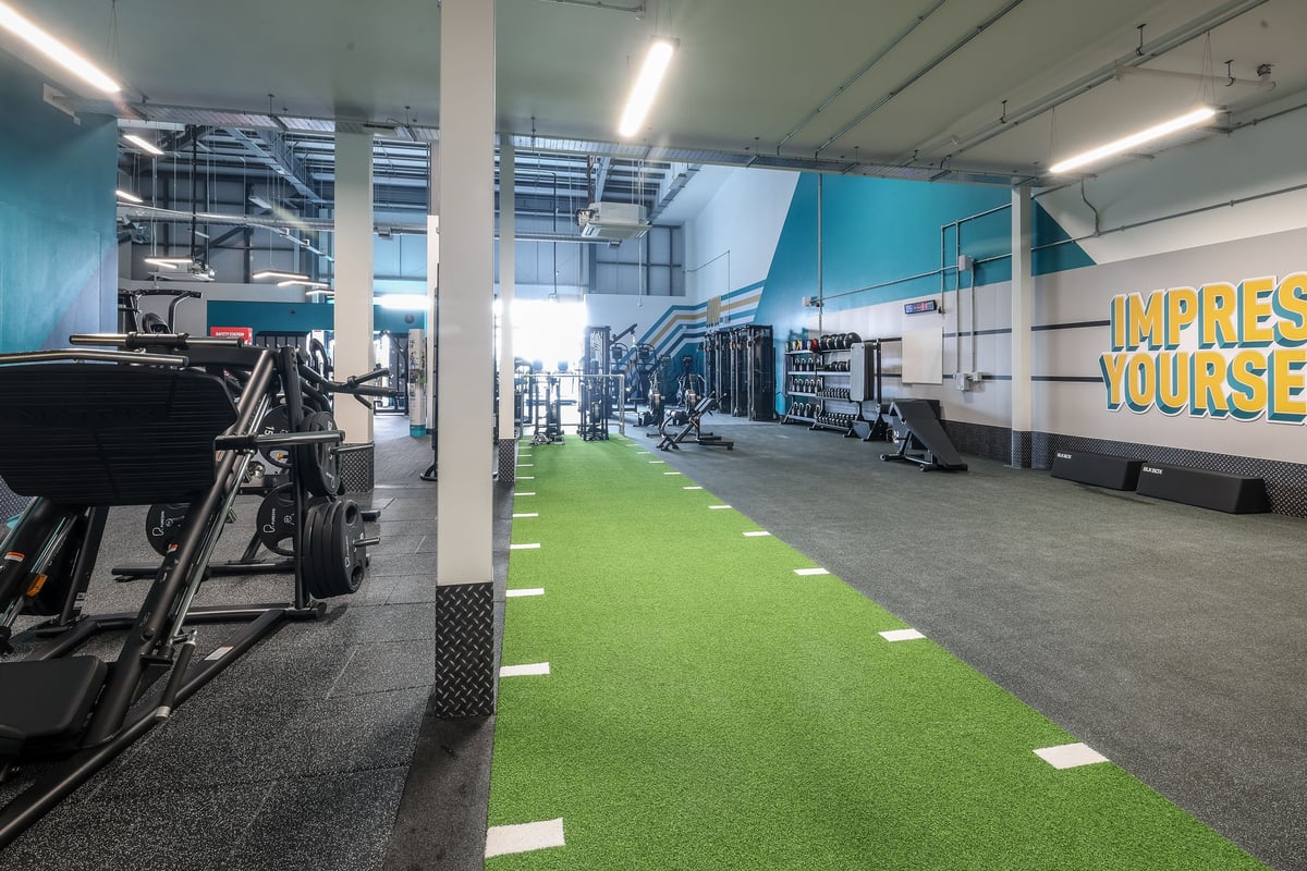 PureGym Bishop Auckland: Gym studio area with green turf flooring, free weights, exercise equipment and trailers.