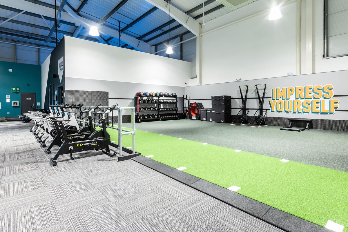 PureGym Torquay Bridge Retail Park: Resistance training area with weight racks, free weights, and turf section.