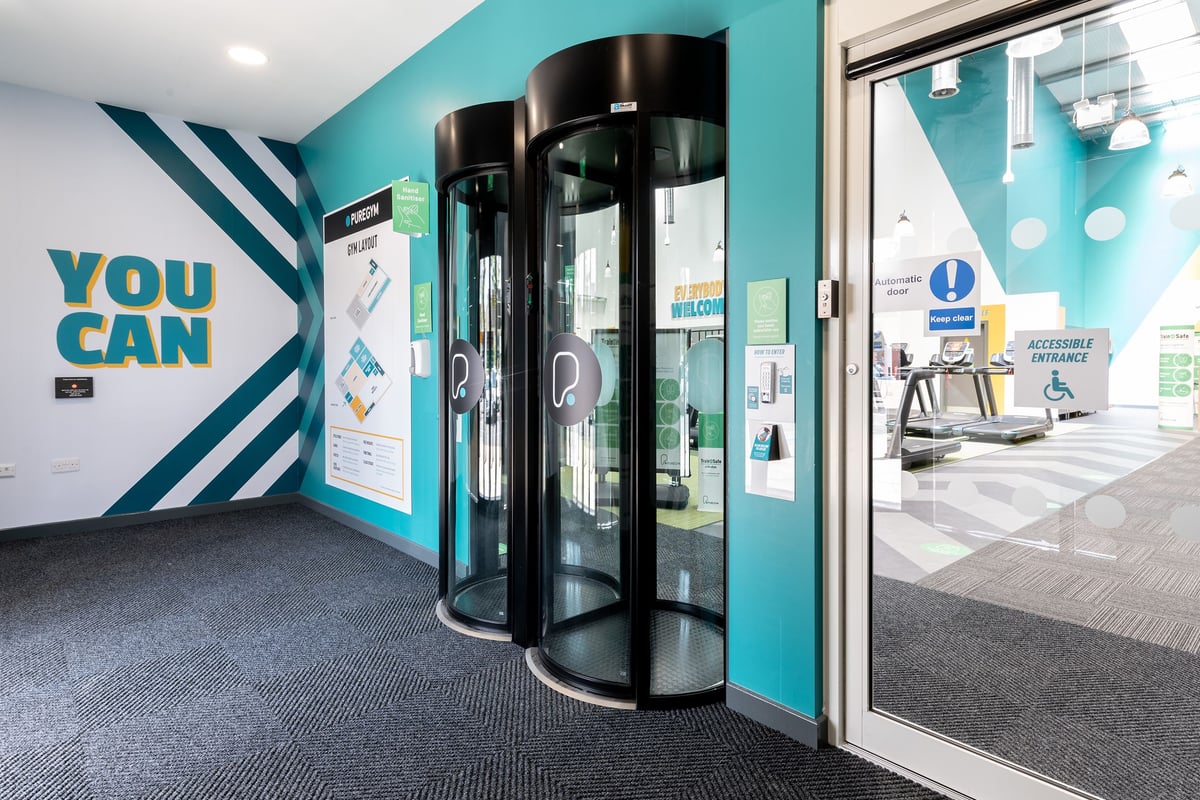 PureGym Colchester Retail Park: Revolving doors, vending kiosks, teal and black colour scheme, "You Can" branding.