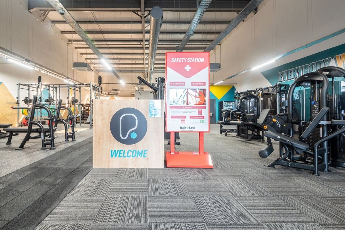 PureGym Lanark: Resistance machines, free weights, benches and rubberized flooring in a spacious gym interior.
