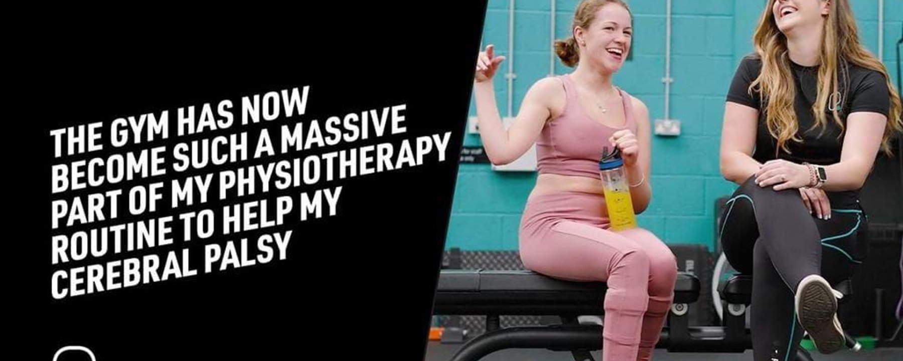 Two women in gym wear sitting on a bench laughing, one holding a water bottle.