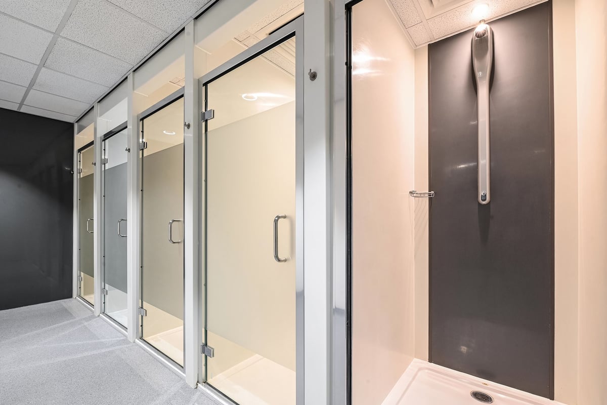 PureGym Canterbury Sturry Road: Glass partition walls, door handles, and private shower stalls.