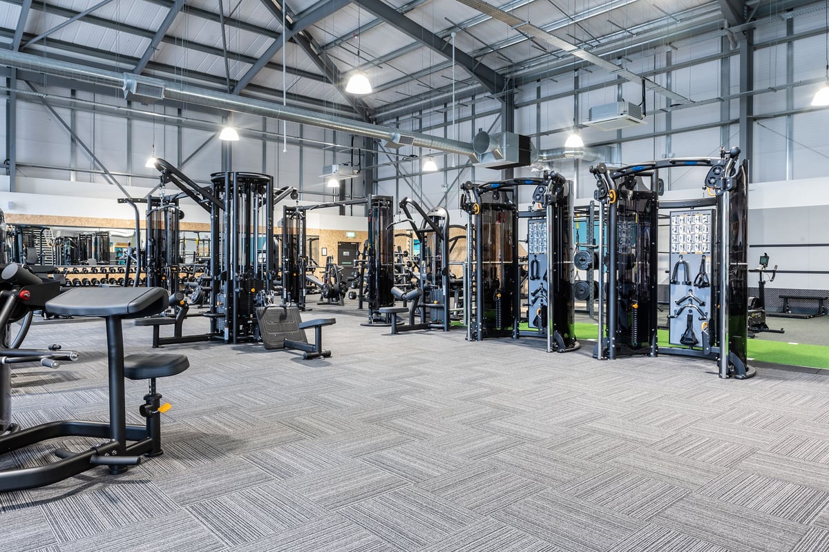 PureGym Cirencester: Strength training rigs, weight stacks, cable machines and floor mats in a well-equipped gym facility.