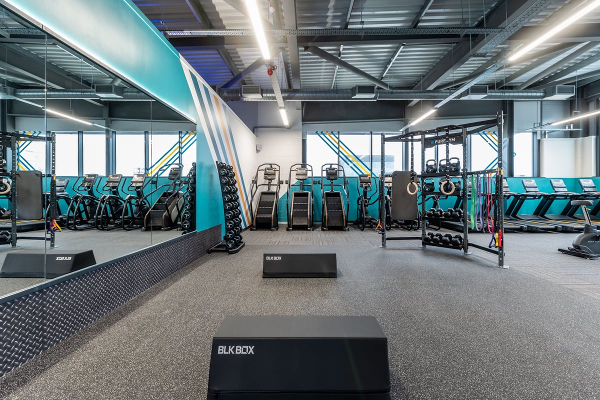 PureGym Plymouth Derriford: Rows of stationary bikes, treadmills, weight racks, and benches in a modern fitness studio.