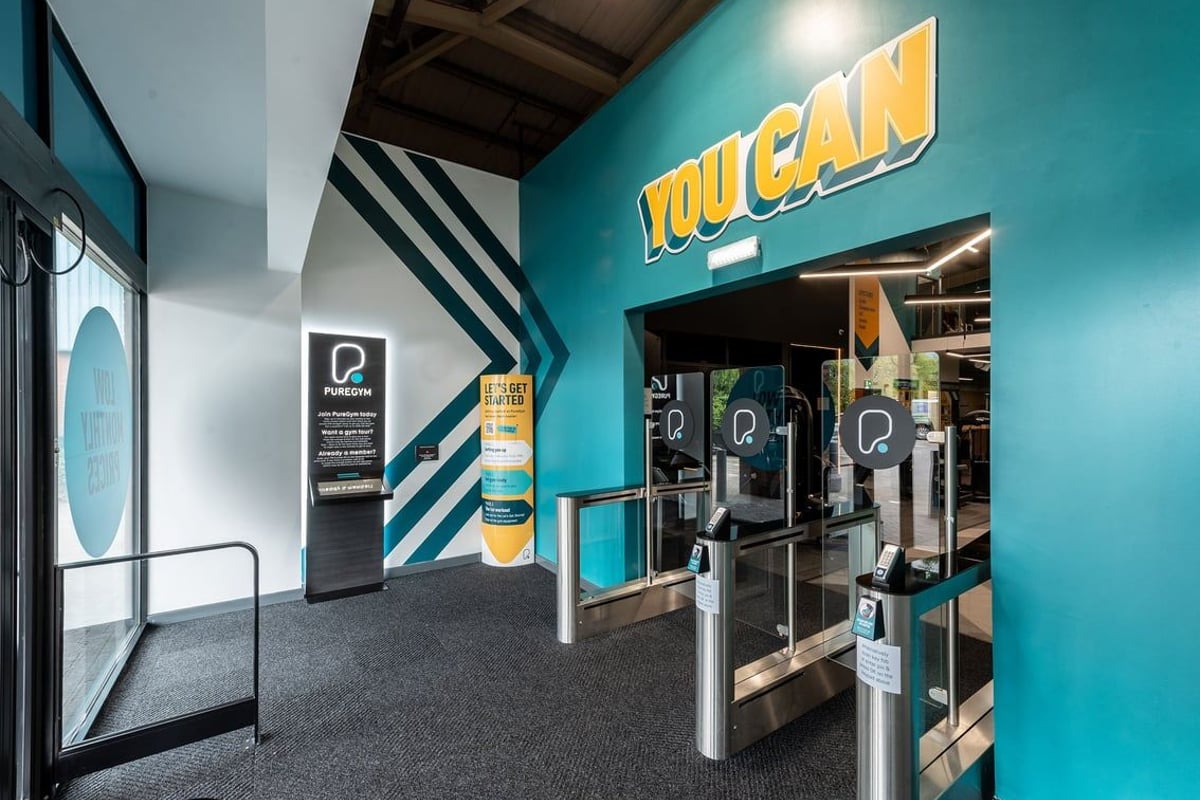 PureGym Macclesfield Silk Road: Toucan self-service kiosks in a teal and black interior space.