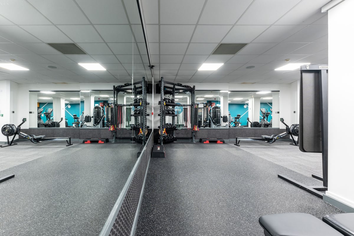PureGym Luton And Dunstable: Gym facility with racks, benches, weights, exercise machines, and rubberized flooring.