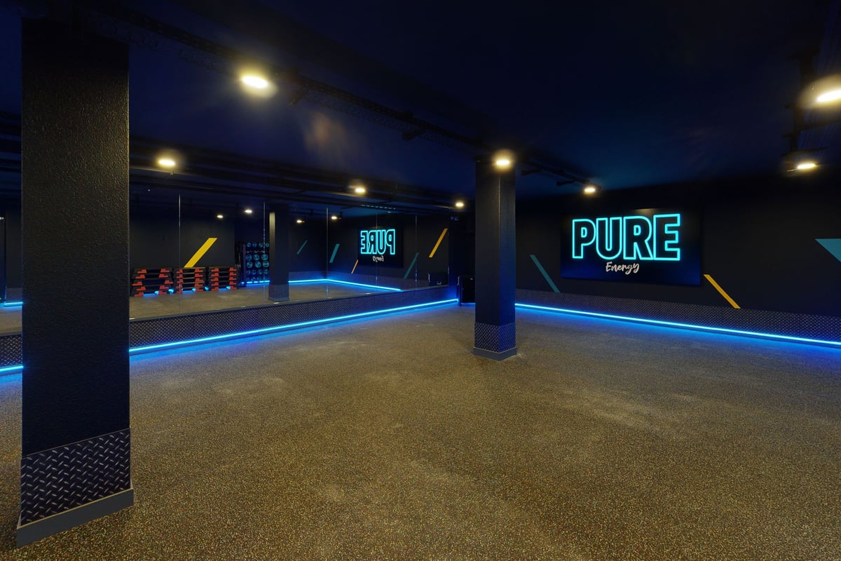 PureGym Bern Lorraine: Décoration murale Neon Pure Energy dans le studio de gym.