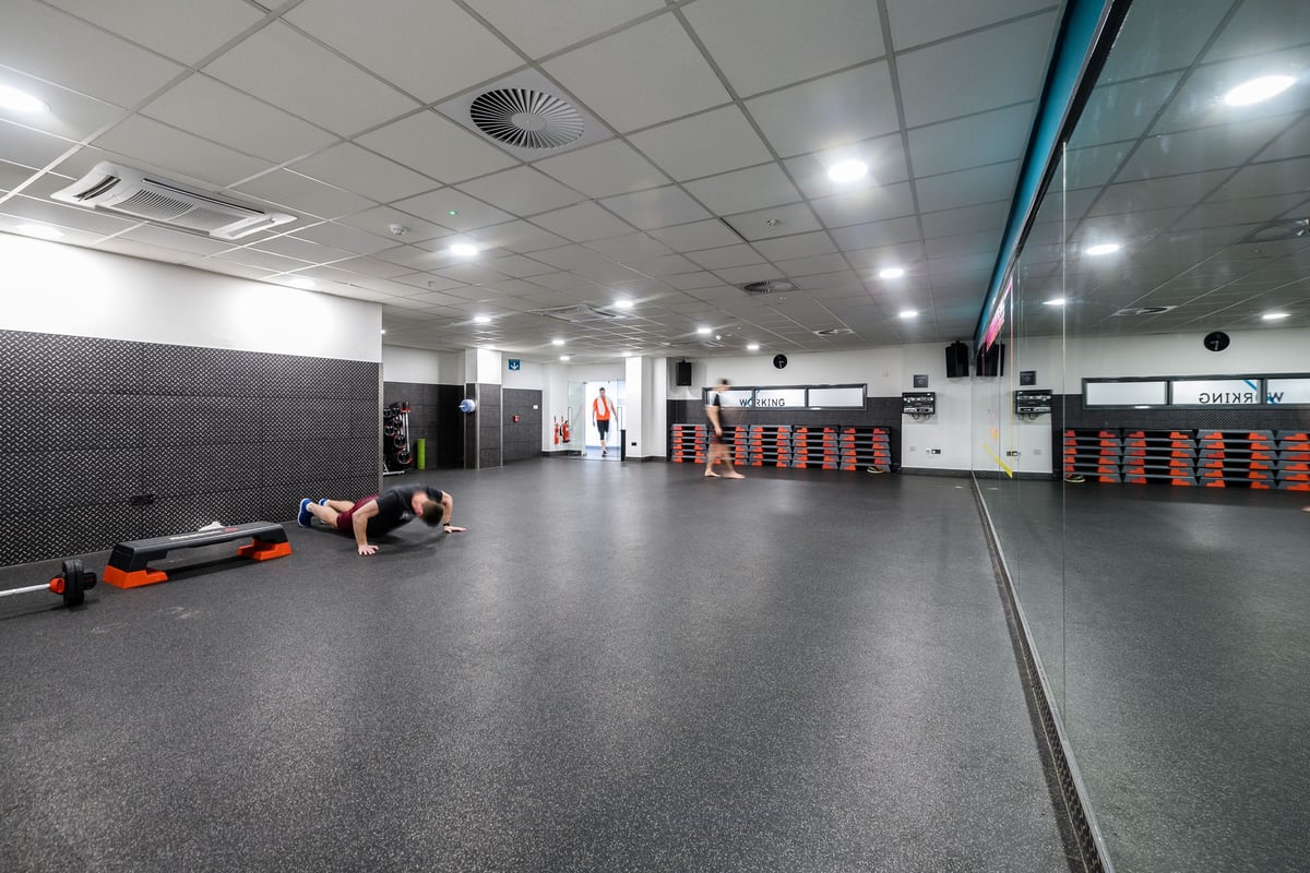 PureGym London Moorgate: Rubberized floor, weight racks, mirrored wall, weightlifting platforms, exercise equipment.