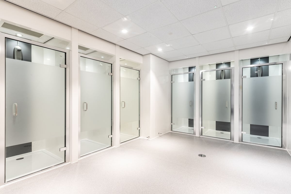 PureGym Southampton Bitterne: Rows of glass entry gates with stainless steel framing and rubberized flooring.