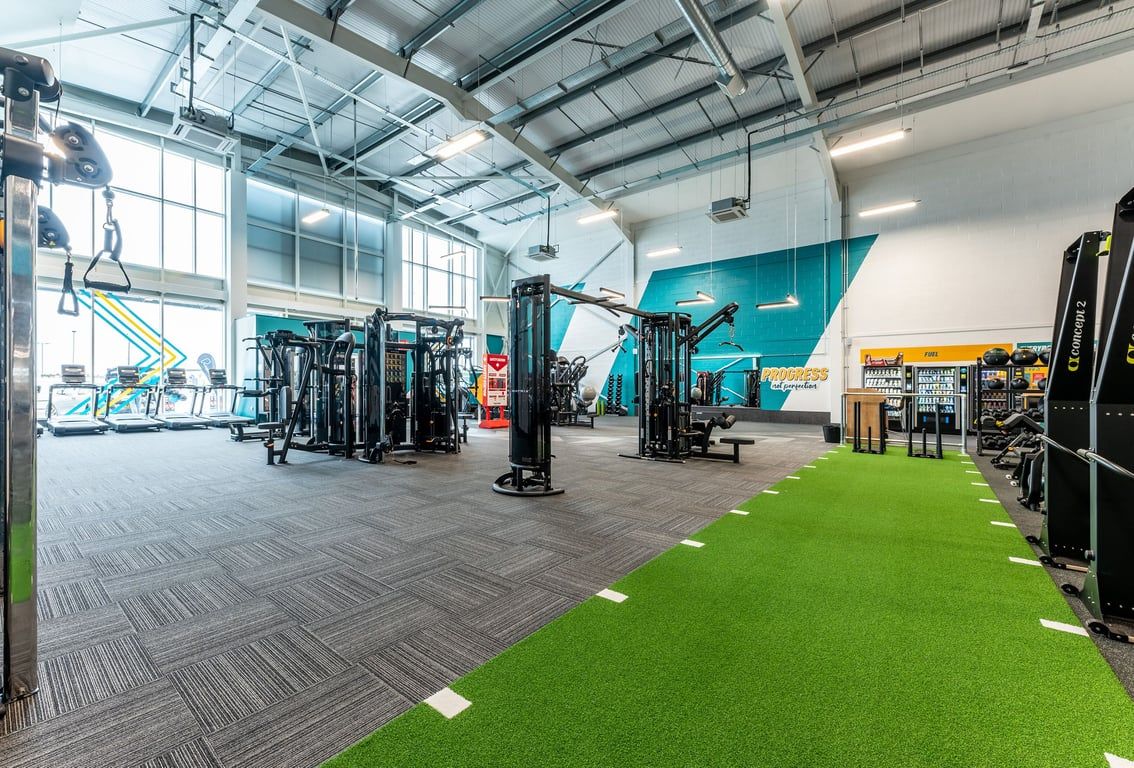 PureGym Liverpool Edge Lane: Functional training area with resistance machines, turf, free weights, and rubberized flooring.