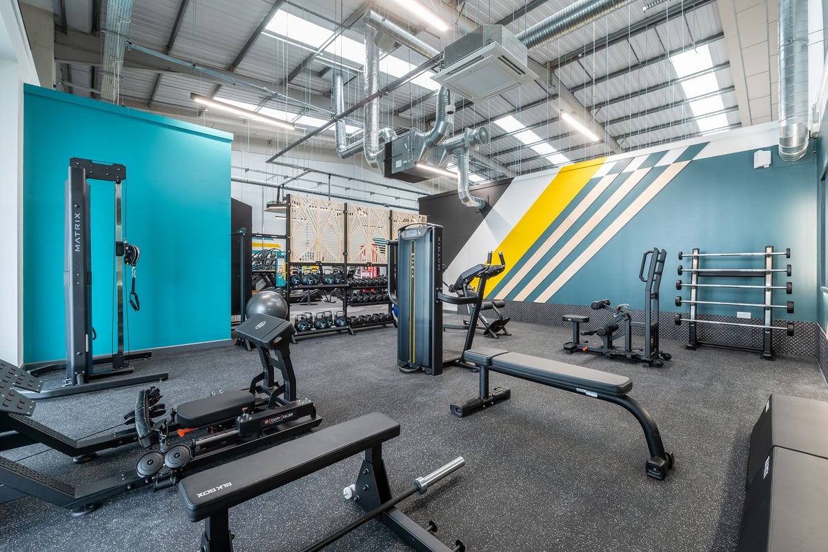 PureGym Thamesmead: Strength machines, benches, free weights, mirrors, and industrial interior gym setup.