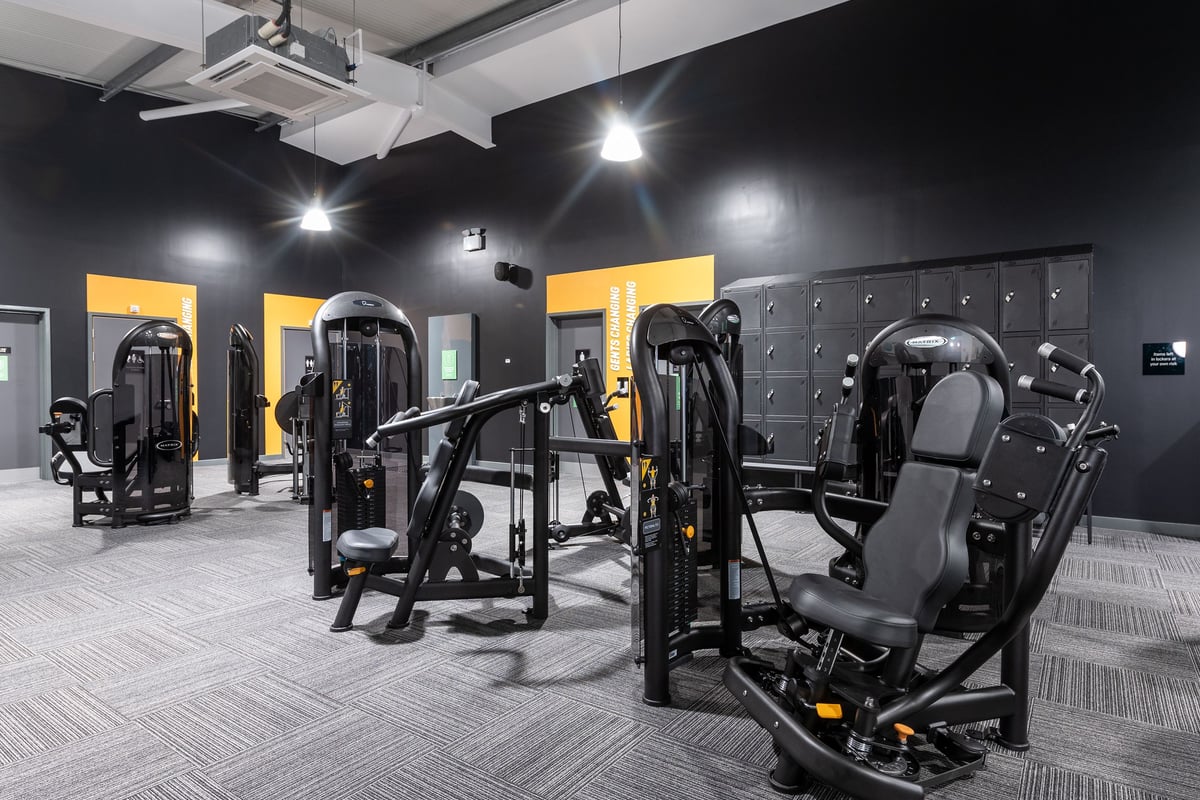 PureGym Andover: Weight machines, treadmills, weight racks, and rubberized flooring in a dimly lit gym space.