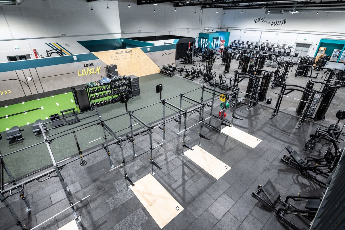 PureGym York: Rows of weight racks, free weights, turf area for functional training in a spacious gym layout.