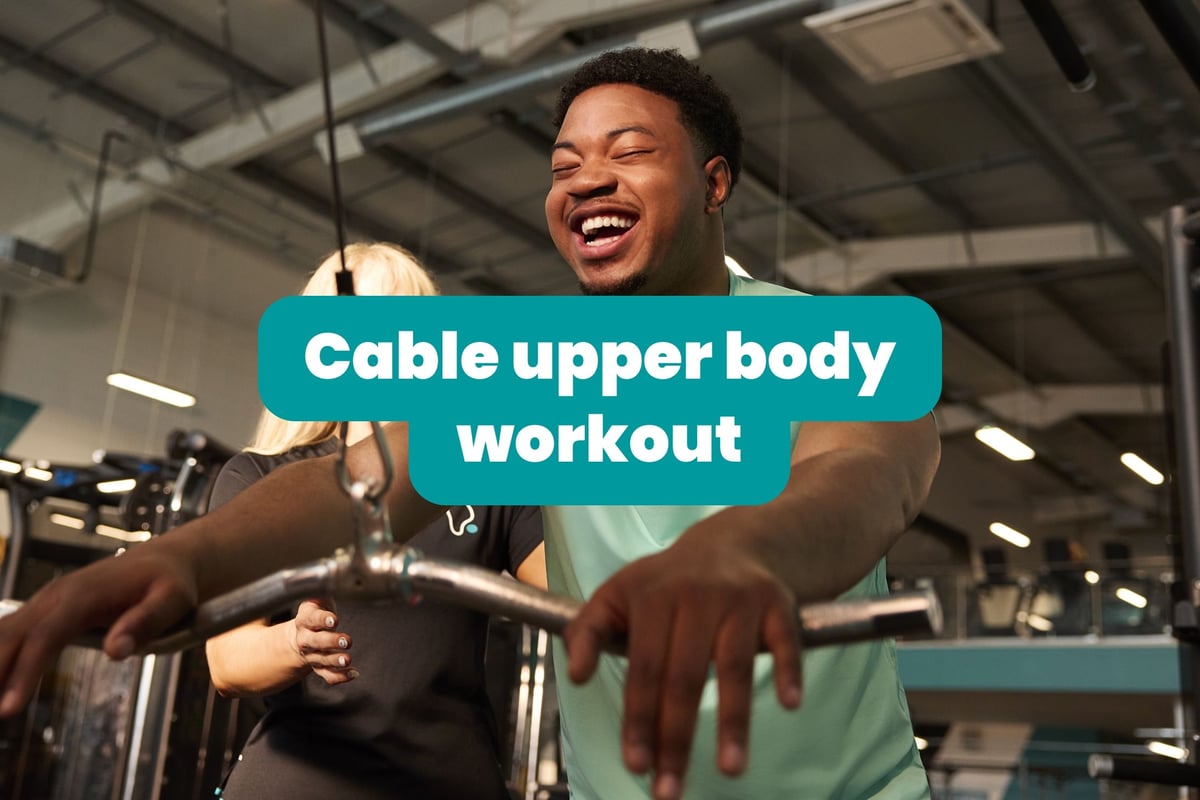 Mann lächelt beim Trainieren an der Kabelmaschine für Oberkörper im Fitnessstudio