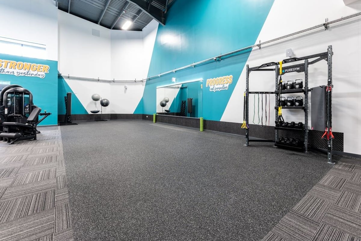 PureGym Sevenoaks: Functional training area with pullup rig, heavy bags, rubberized flooring in teal and green colour scheme.