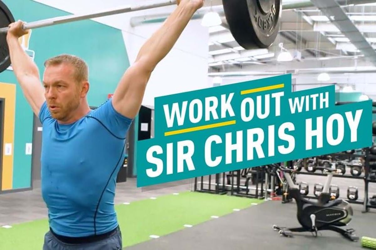 Man lifting barbell overhead in gym with workout text beside him