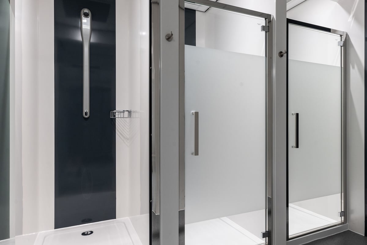 PureGym Kettering: Shower stalls with frosted glass doors and stainless steel handles.