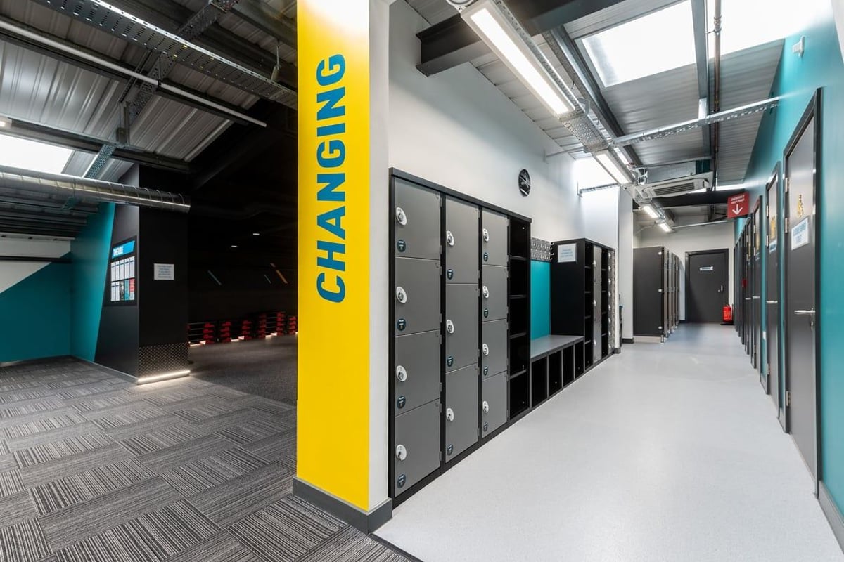 PureGym Northallerton: Lockers, benches and storage cubbies in a changing room area.