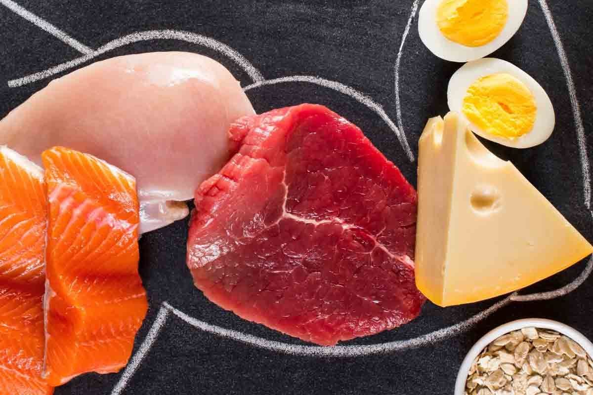 Leberförmige Kreideumrisse auf schwarzem Hintergrund umgeben von proteinreichen Lebensmitt