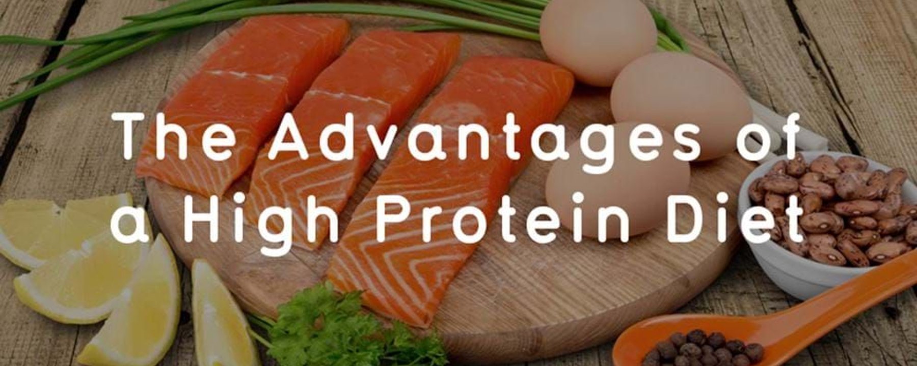 Three salmon fillets, eggs, lemon wedges, beans, herbs, and peppercorns on wood
