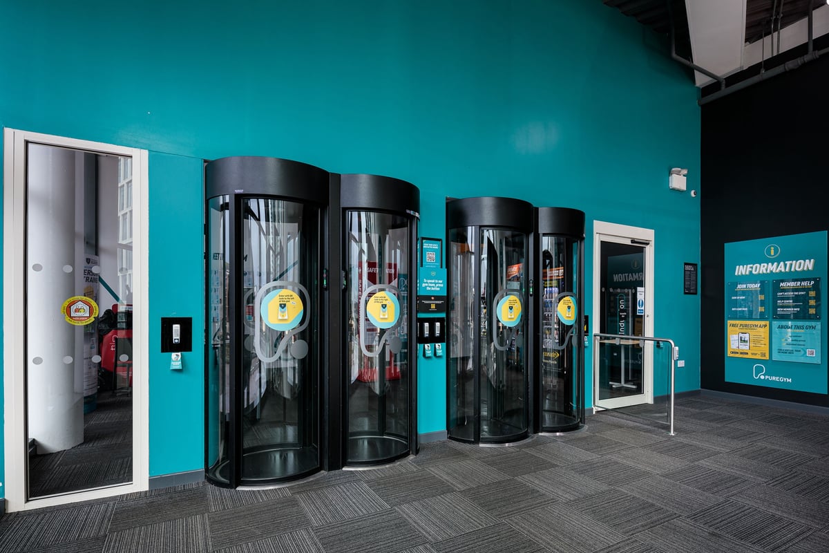 PureGym Cardiff Central: Rows of entrance pods with teal walls.