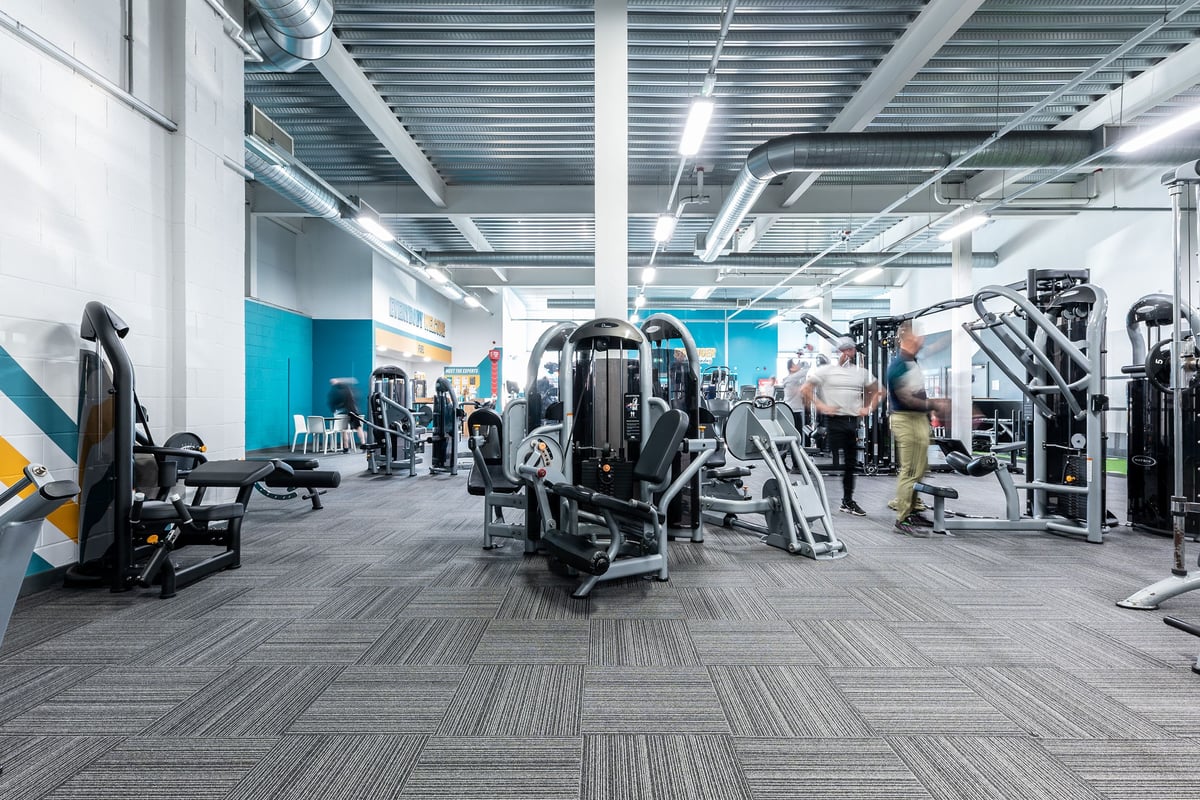 PureGym Hednesford Cannock: Rows of exercise machines, weight racks, benches, and rubberized flooring in a contemporary gym.