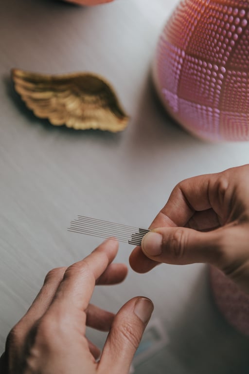 Fine filament acupuncture needles held before a women's health treatment at Palomino Massage & Acupuncture in Marble Falls, TX